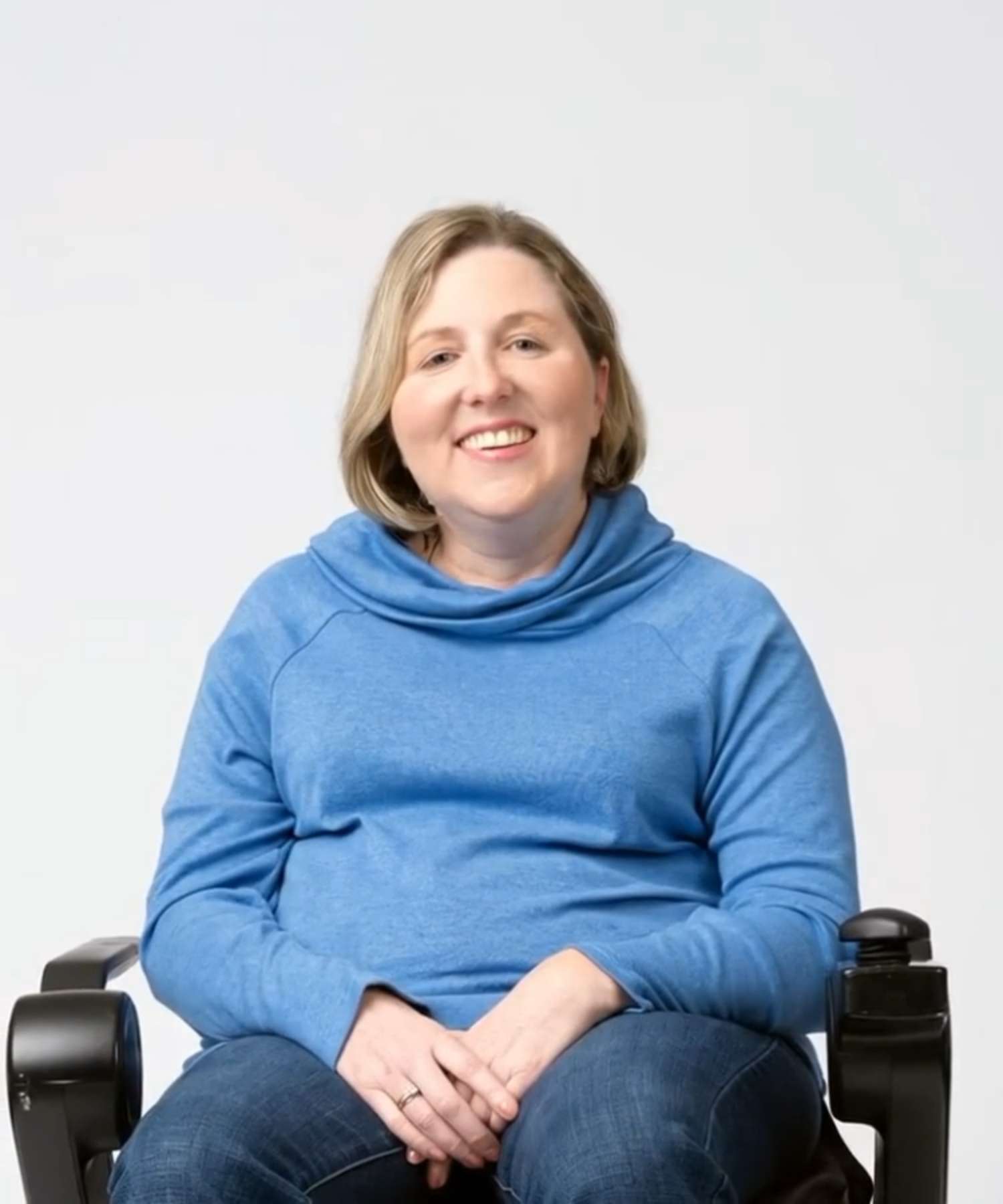An open book. On the left spread, Erin, a young
woman with FA smiles while sitting in her
wheelchair.